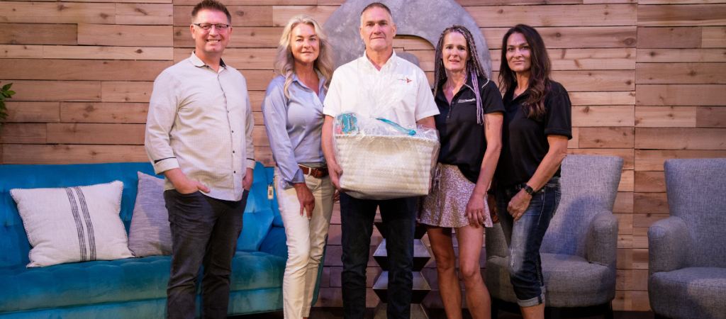 The transcend energy group poses with RevRoad CEO Derrin Hill while holding their welcome gift basket for becoming the newest RevRoad portfolio company.